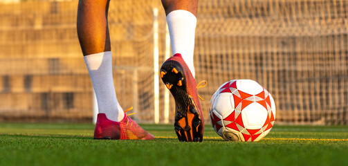 Football player feet running with the ball in front of the field. Player feet with the ball scoring...