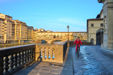 cheerful senior woman cycling with her electric mountain bike in downtown of Florence  with famous...