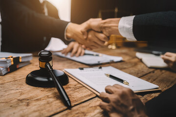 Middle age partner lawyers attorneys shaking hands after discussing a contract agreement done.