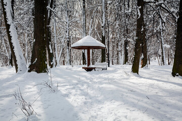 Snowfall in Moscow. Snow-covered benches in the park