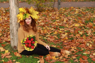 Young woman with colored autumn leaves in her hair