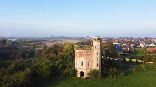 Drone footage of an old tower remaining on the outskirts of a village