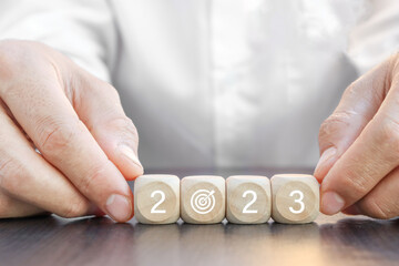 New Year's concept. Hand holding wooden cube with 2023 goal icon. Business growth success concept.