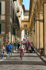 cheerful senior woman  cycling in the crowded streets of Florence Tuscany, Italy