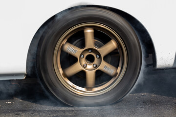 Car wheel spinning wheel and smoking, Race car doing lot of smoke on race track, Car wheel drifting and smoking on track.