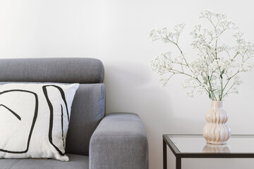 grey couch, pillows and flowers in living room