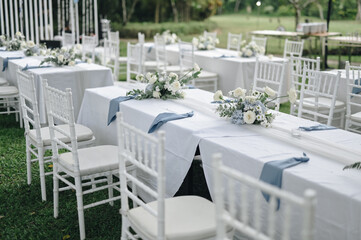 Fairy-tale with blue and white accent flowers theme. Clean white table setting for wedding ceremony or reception. Family intimacy dinner outdoors with starlight.