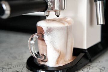 Coffee machine overfilled cup with coffee close up