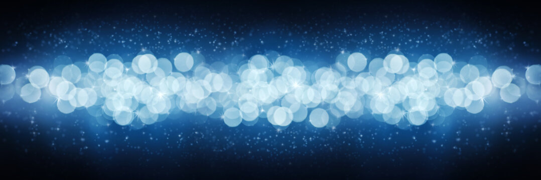 Winter blue background with blurry lights and glitter. Concept of Christmas, New Year and holiday. Banner defocused from the light of garlands.