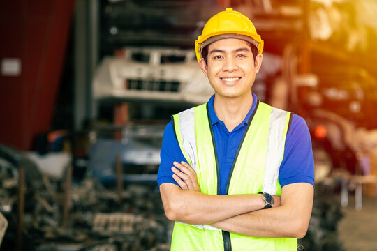 Asian male engineer worker standing arm crossed confident happy smile for enjoy working in factory looking camera