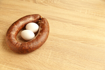 Kangal sucuk made from various spice mixtures used in Turkish cuisine and two white eggs, on oak cutting board