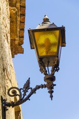Fototapeta na wymiar Vertical shot of vintage street flashlight attached to a stone building