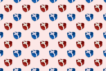 A pattern of blue and red colored gift boxes with a bow made with ribbon isolated on pink uniform background.