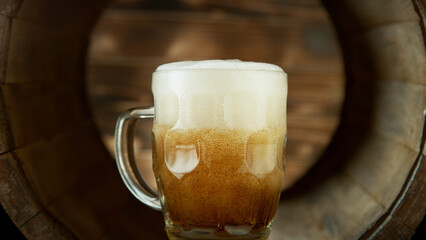Glass of beer inside old wooden barrel.