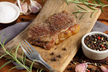 Grilled beef steak medium rare on wooden cutting board. Top view, close up