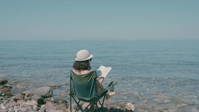 What stories will this summer bring? Beautiful woman reading on beach