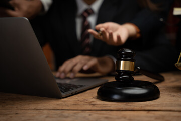 Close up lawyer businessman working or reading lawbook in office workplace for consultant lawyer concept.Lawyer working at table in office, focus on scales of justice