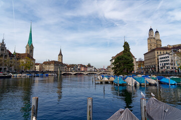 Skyline of the old town of Zürich with churches Women's Minster,  St. Peter and Great Minster with Limmat River on a blue cloudy autumn day. Photo taken October 30th, 2022, Zurich, Switzerland.