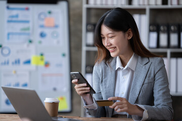 Smiling business asian woman using phone in office. Small business