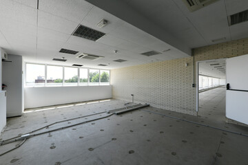 tall office building with large window and awaiting renovation of flooring and furniture