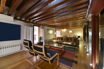 Living room with wooden furniture, matching flooring and exposed wooden beams on the ceiling