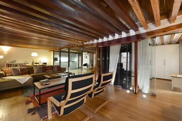 Fototapeta na wymiar Living room with wooden furniture, matching flooring and exposed wooden beams on the ceiling