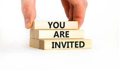 You are invited symbol. Concept words You are invited on wooden blocks. Businessman hand. Beautiful white table white background. Business and you are invited concept. Copy space.