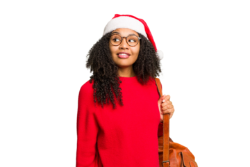 Young african american student woman wearing a christmas hat isolated looks aside smiling, cheerful and pleasant.