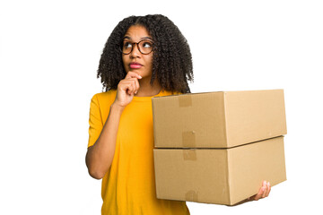 Young african american woman moving to other house while picking up a box full of things isolated...
