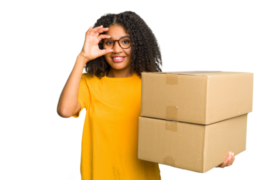Young african american woman moving to other house while picking up a box full of things isolated excited keeping ok gesture on eye.