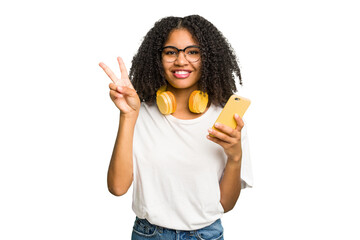 Young african american woman listening to music with yellow headphones isolated showing number two with fingers.