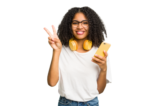 Young african american woman listening to music with yellow headphones isolated showing number two with fingers.
