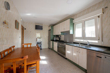 Large kitchen room with furniture covering one wall and a pine table with matching chairs
