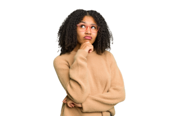 Young african american woman isolated thinking and looking up, being reflective, contemplating, having a fantasy.