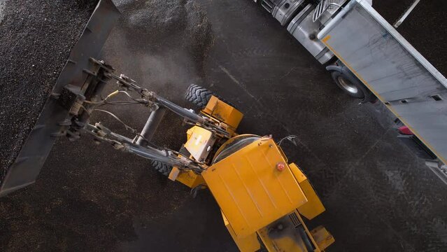 Wheel bucket loader loads a truck with sunflower seeds. High quality 4k footage.