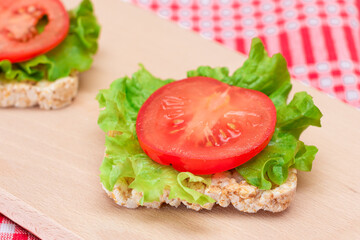 Rice Cake Sandwiches with Tomato and Lettuce on Wooden Cutting Board. Easy Breakfast. Diet Food. Quick and Healthy Sandwiches. Crispbread with Tasty Filling. Healthy Dietary Snack