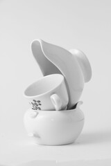 Vertical shot of a set of white crockery on top of each on a white background