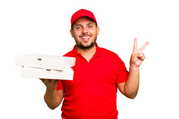 Pizza delivery caucasian man with work uniform picking up pizza boxes isolated joyful and carefree showing a peace symbol with fingers.
