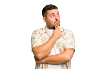 Young caucasian man isolated thinking and looking up, being reflective, contemplating, having a fantasy.