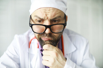 A cross-eyed bearded man is looking into the frame. Eye disease. The concept of a crazy medical...