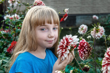 11 year old girl with long white hair with a dahlia flower. Portrait of little toddler girl...