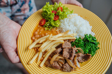 Prato de arroz, feijão, salada, batata e carne