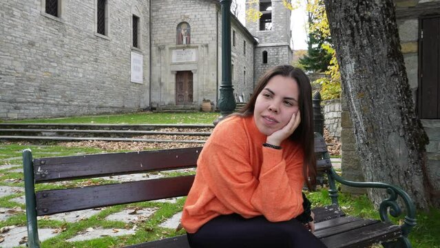 Nymfaio, Greece. A girl sitting on a bench as autumn arrives.