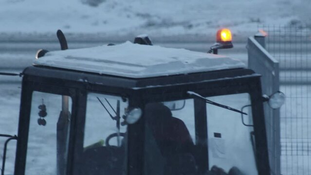 Orange flasher on the roof of a snowplow with snow storm in winter. Copy space for text, evening