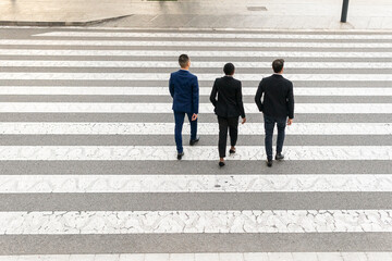 Multiethnic coworkers walking on crosswalk