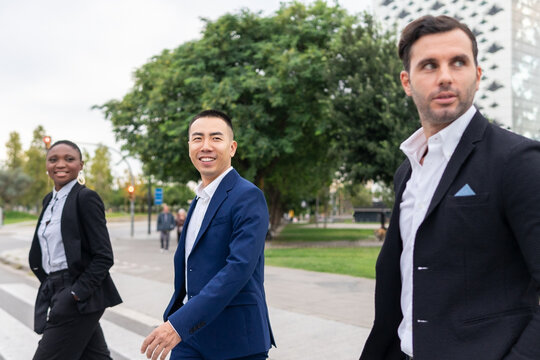 Multiethnic coworkers walking on crosswalk