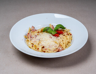 Close-up of Carbonara pasta with cheese and bacon in a white plate. Italian cuisine. Tasty food.