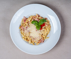 Close-up of Carbonara pasta with cheese and bacon in a white plate. Italian cuisine. Tasty food. Top view.