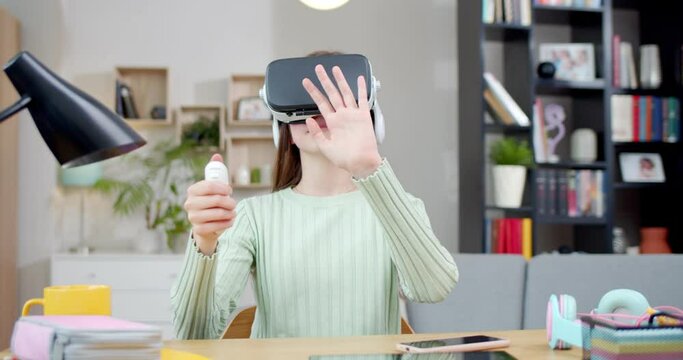 Teenager girl playing games on VR headset. Virtual reality helmet and joystick. Young schoolgirl moving hands and head in kids room playing VR game. Simulation glasses. Virtual reality concept.