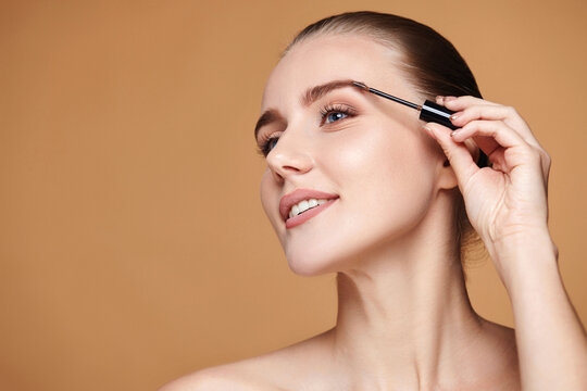 woman with perfect shape eyebrows on beige background.